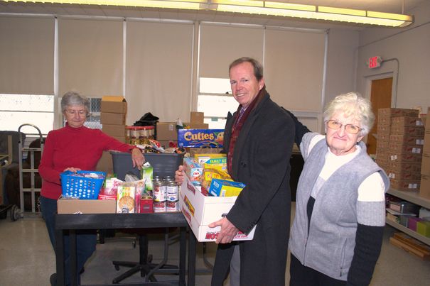 Norfolk County Register of Deeds William P. O’Donnell carries in food donations collected during the Registry of Deeds Annual Holiday Food Drive with the help of Natale Lee, 15-year volunteer and Ann Toland, Marge Crispin Center Co-Director at the Marge Crispin Center in Braintree.
