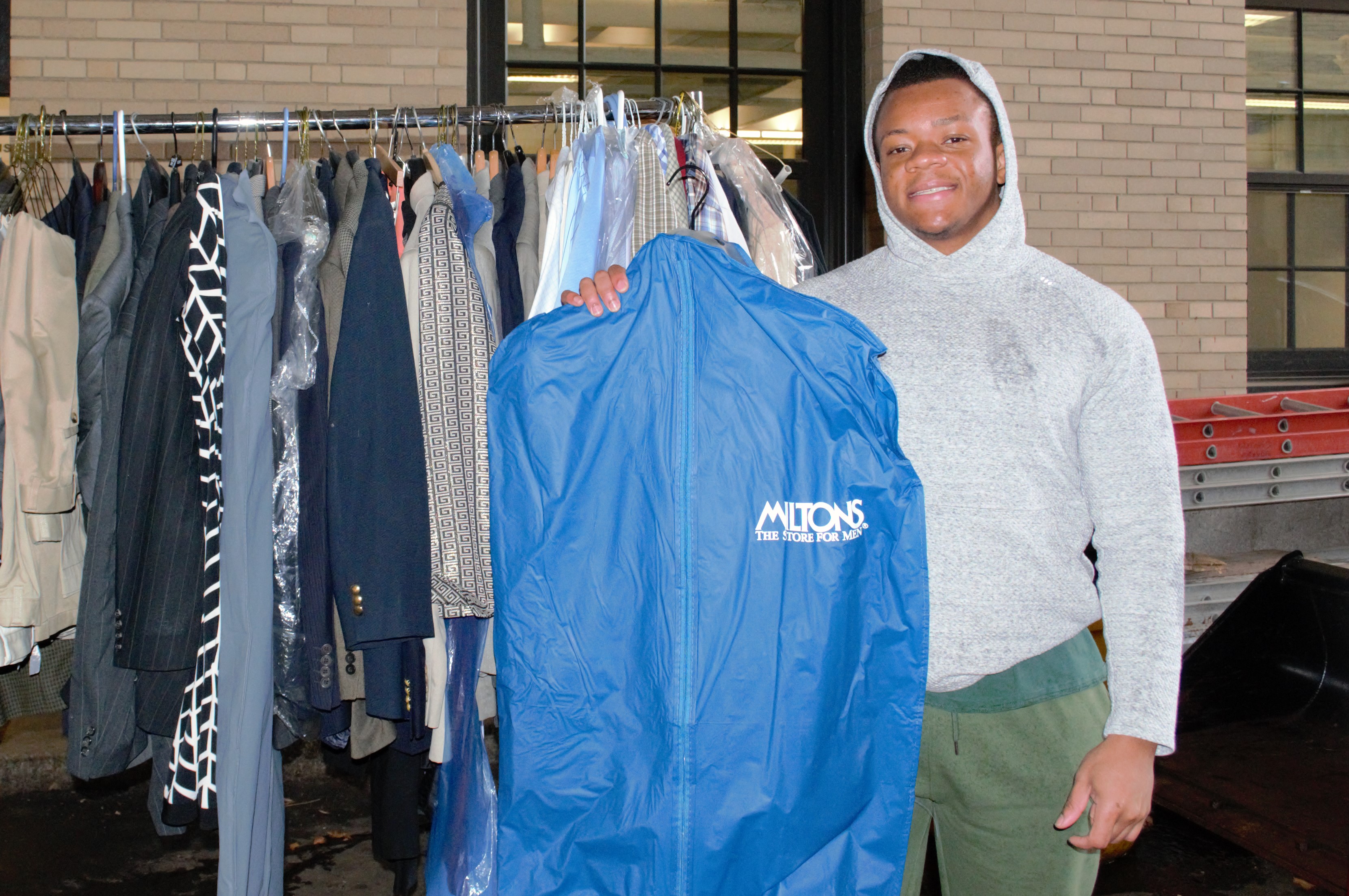 Macdony Charles, Program Manager for Inner City Weightlifting, holds up a suit from the collection of the more than 100 articles of clothing donated to the organization through the “Suits for Success” program.