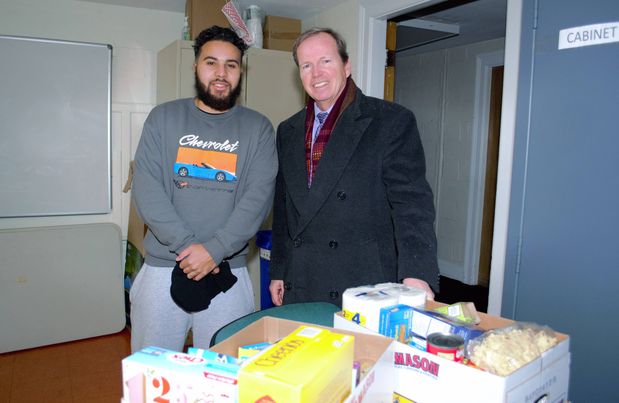 Norfolk County Register of Deeds William P. O’Donnell (right) delivers food donations collected during the Registry of Deeds Annual Holiday Food Drive to Khalil Melton volunteer at the Milton Community Food Pantry.