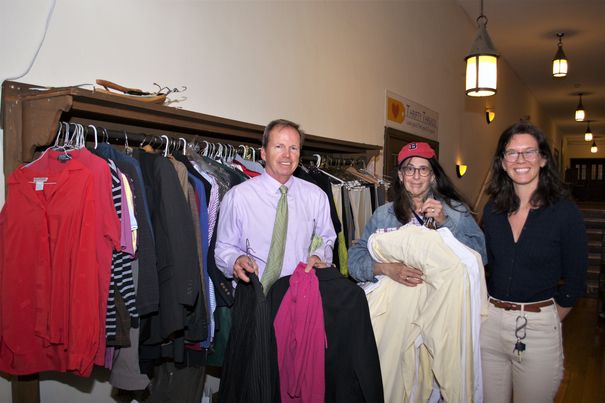 Norfolk County Register of Deeds William P. O’Donnell shows Beth Klein, 7-year volunteer for thrifty threads (left), and Amy Norton, United Parish associate pastor and staff liaison, the more than 100 articles of smart casual clothing and business attire donated through the “Suits for Success” program.