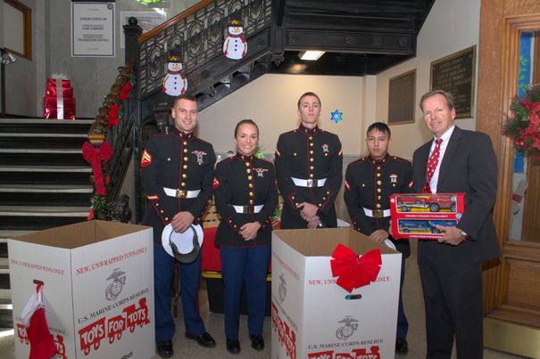 Flynn, Pfc. Jeffery Manna, Pfc. Brayan Quinche, all with the 1st Battalion, 25th Marines representing Toys for Tots and Norfolk County Register of Deeds William P. O’Donnell pose for a photo during a Toys for Tots pickup event Dec. 7.