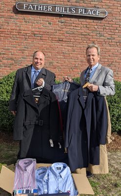 Norfolk County Register of Deeds William P. O’Donnell and John Yazwinski, president and CEO of FBMS, display clothing donated during a tour of the construction site for the Yawkey Housing Resource Center on Nov. 17.